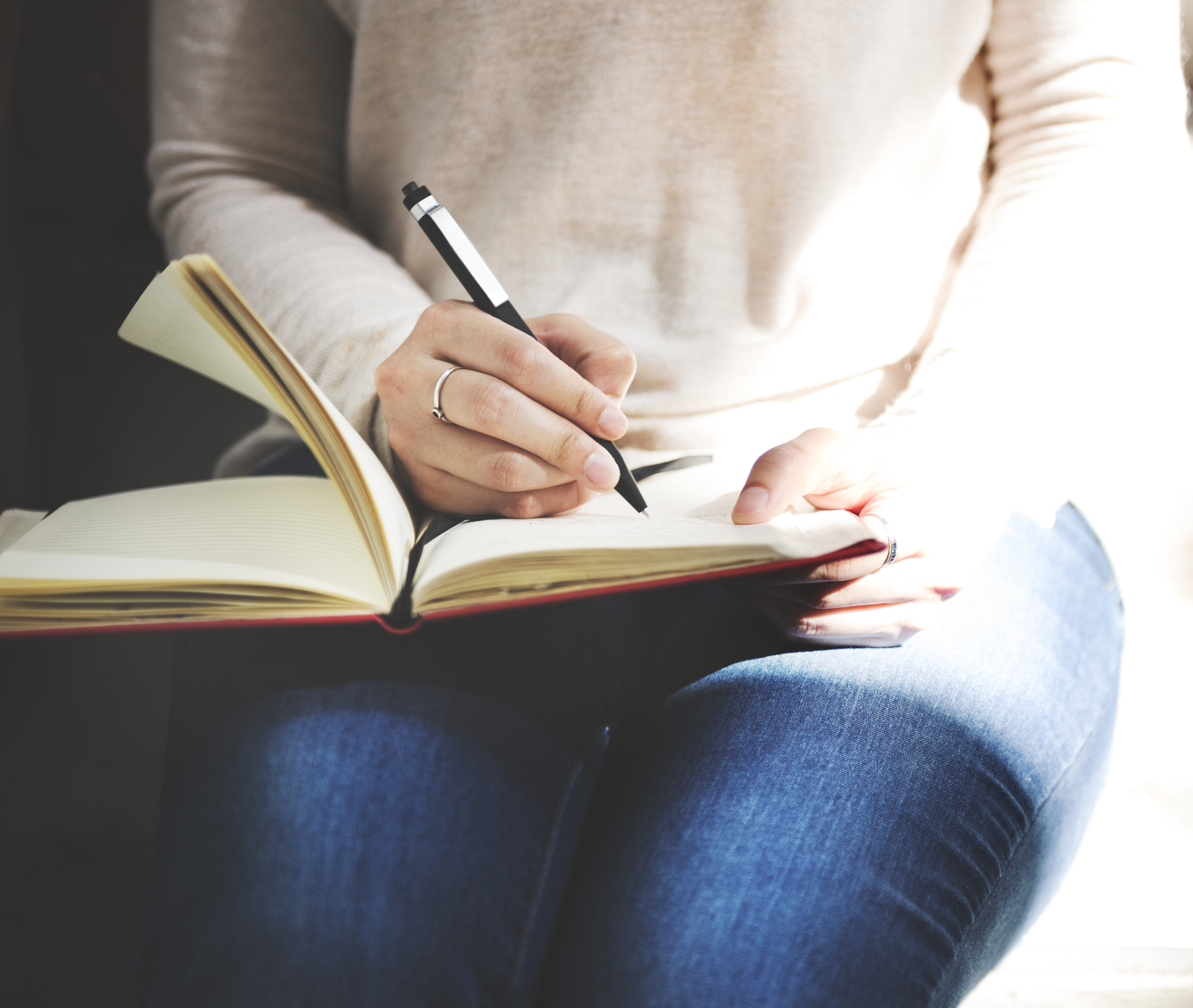 Mujer escribiendo en libreta consejos para escritores principiantes