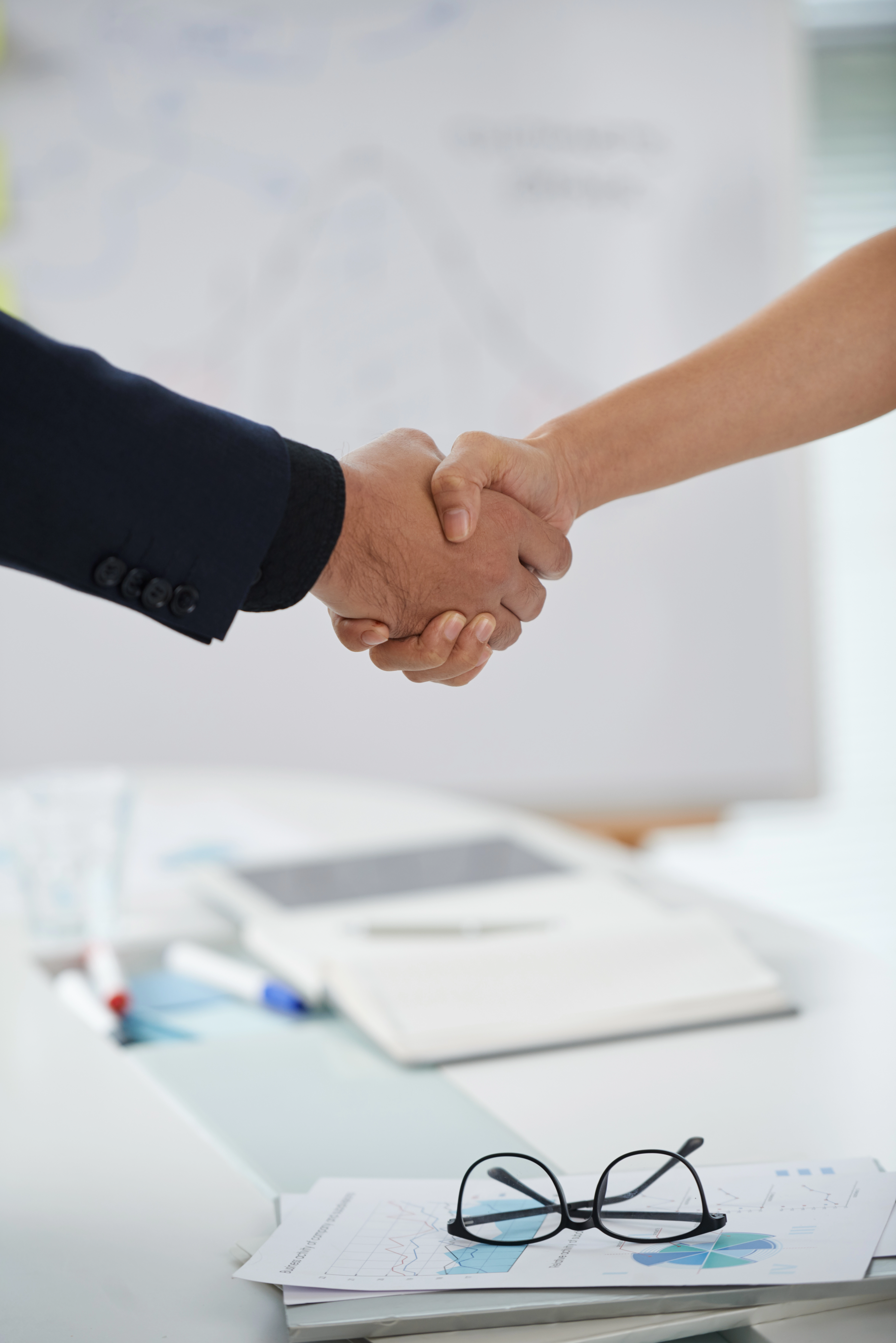 Dos personas dándose la mano en un acuerdo de contrato de edición