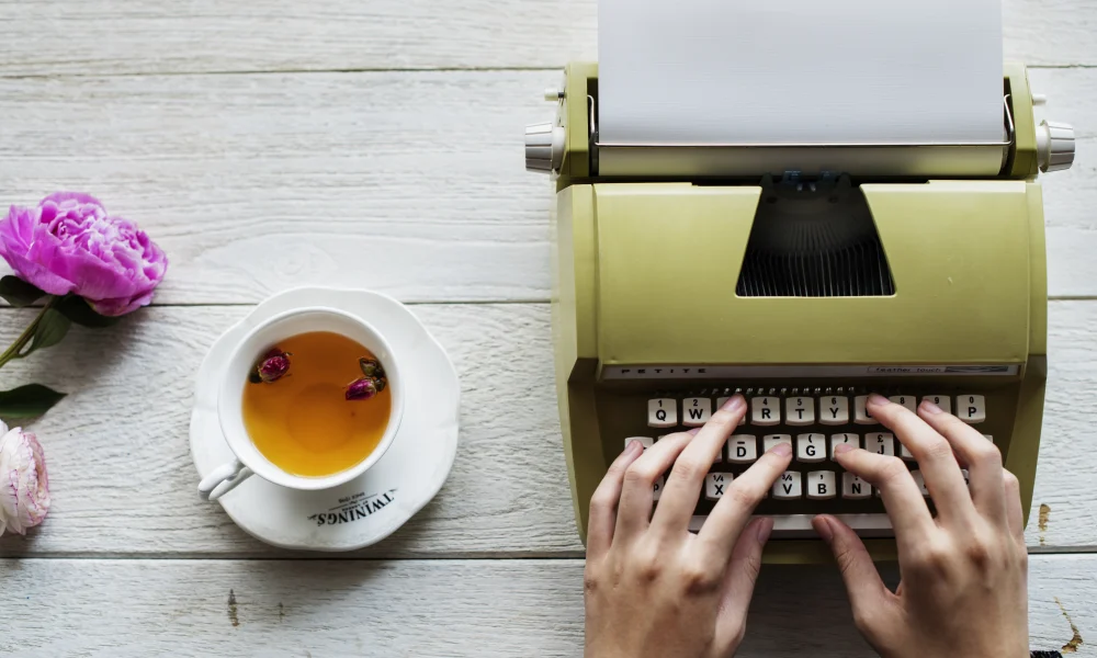 Mujer escribiendo en máquina consejos para escritores principiantes.