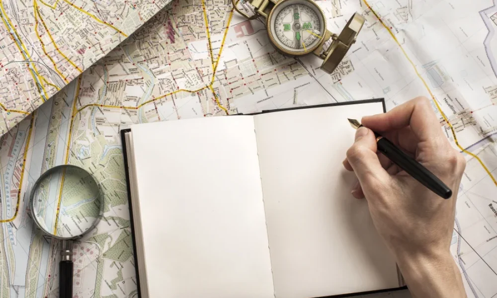 Escritor de mapa o de brújula escribiendo en libreta