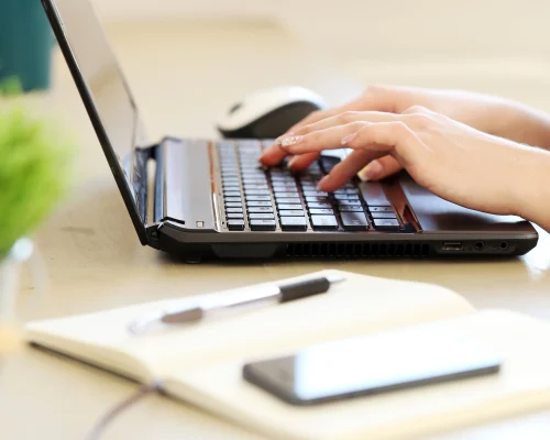 Persona escribiendo en ordenador para publicar en Amazon KDP