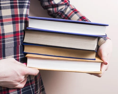 Persona sosteniendo libros de publicar en Amazon KDP