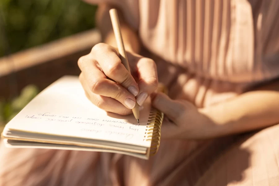 Mujer practicando escritura creativa con cuaderno y lápiz